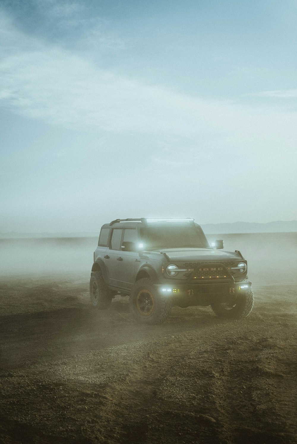 a grey truck driving down a dirt road