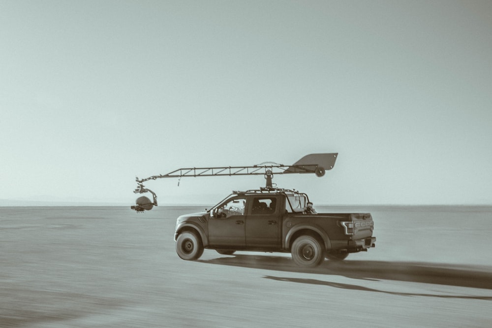 a black and white photo of a truck in the desert