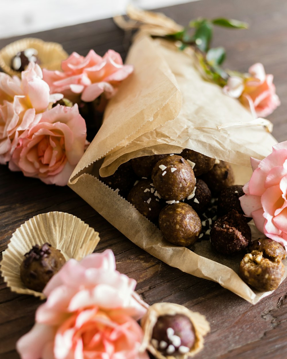 Una bolsa de papel llena de chocolates y flores