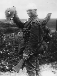 a black and white photo of a man holding a helmet
