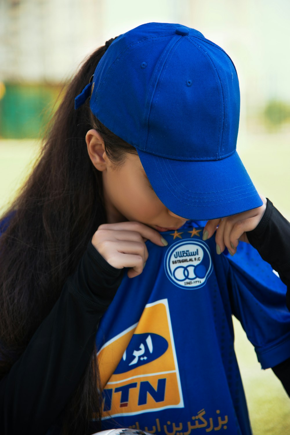 Una giovane donna che indossa un cappello blu e una camicia blu