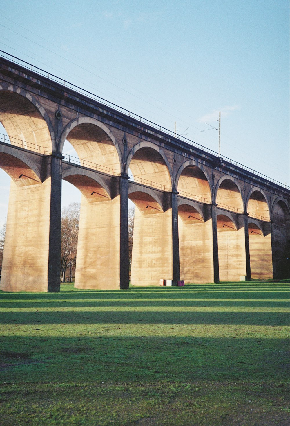 a large bridge spanning over a lush green field