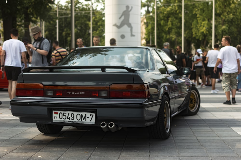 a car parked in front of a crowd of people