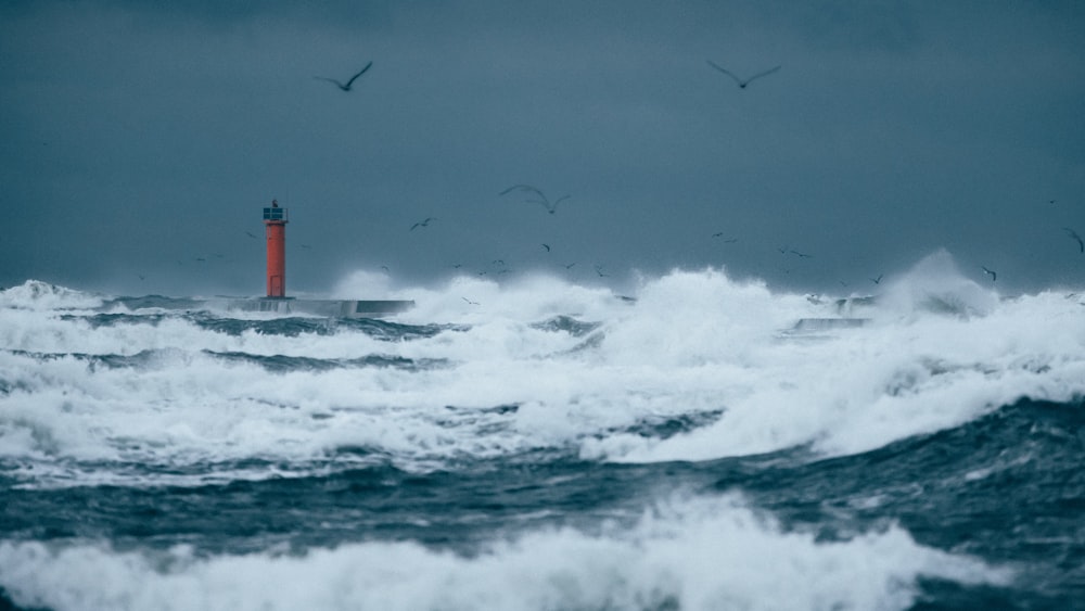 a lighthouse surrounded by waves in the ocean