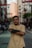 a man standing on a city street with his arms crossed