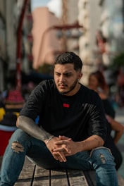 a man sitting on top of a wooden bench