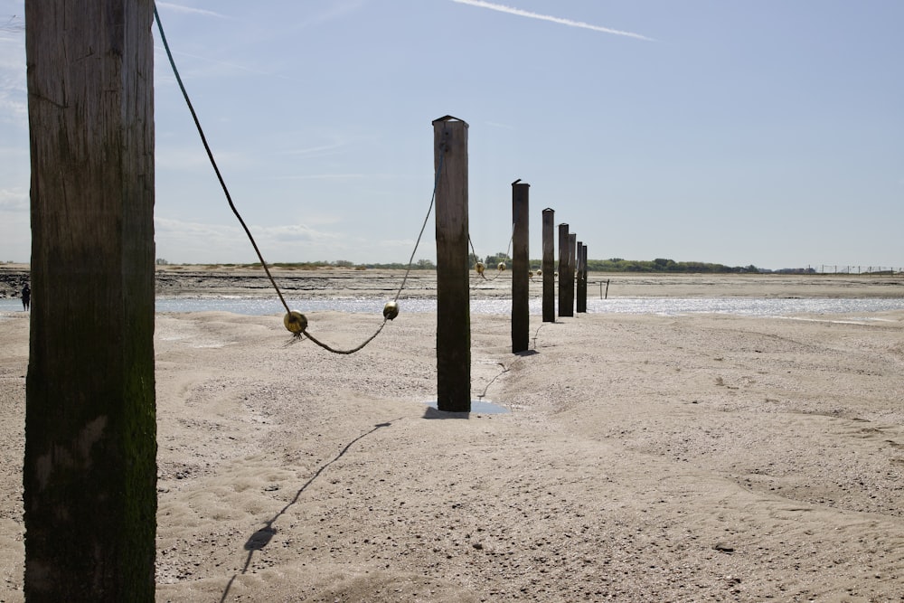 a row of poles sitting on top of a sandy beach