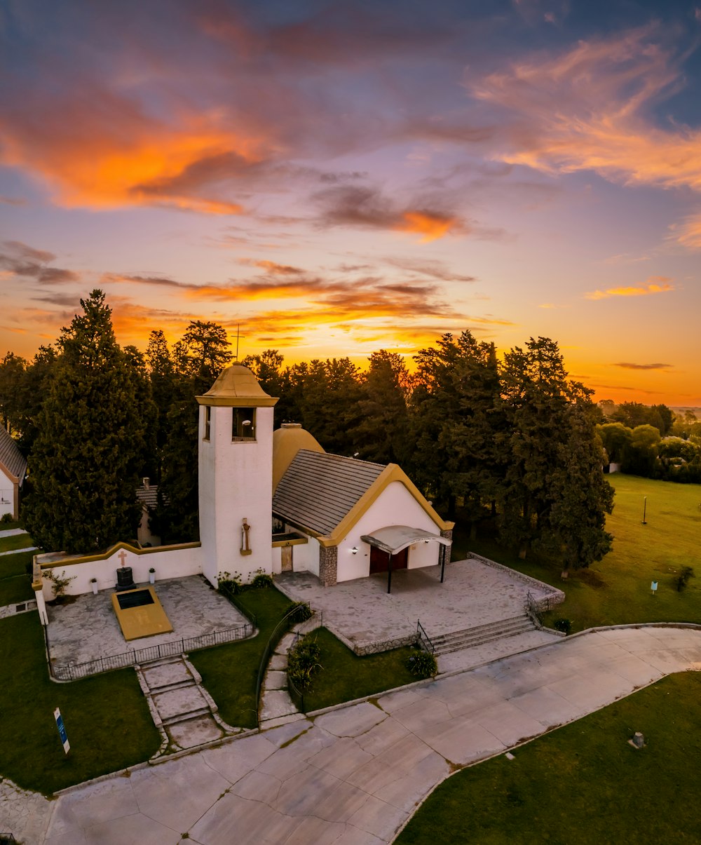 an aerial view of a church with a sunset in the background