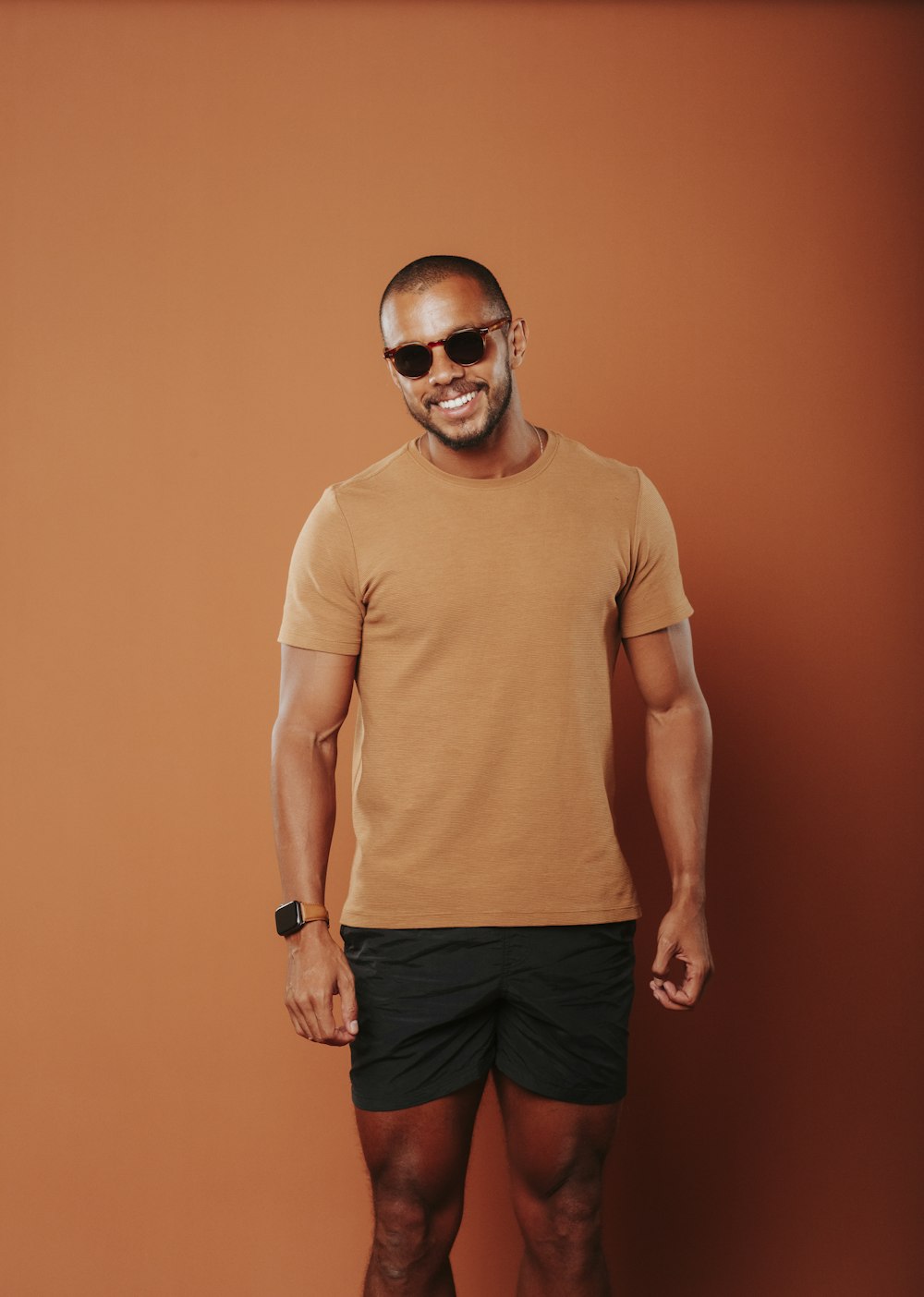 a man in a tan shirt and black shorts