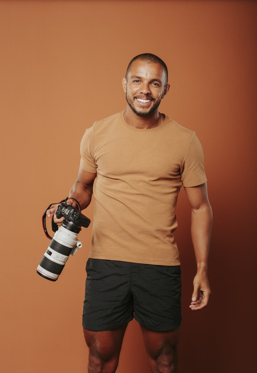 a man holding a camera and a water bottle
