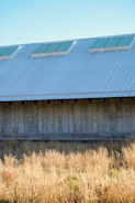 A neatly fabricated metal shed standing in a spacious industrial yard