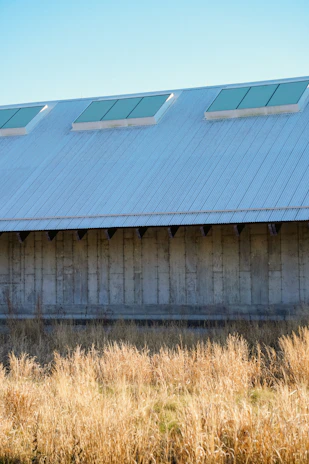 Wide shot of an industrial structure fully shielded by a sleek, weather-resistant shed cover.