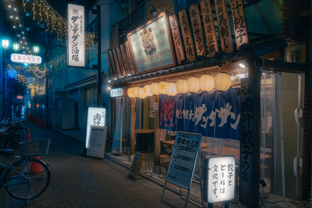 a city street at night with lanterns and signs
