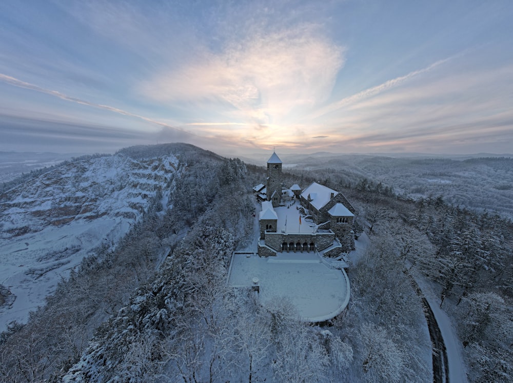 uma vista aérea de uma casa em uma colina nevada