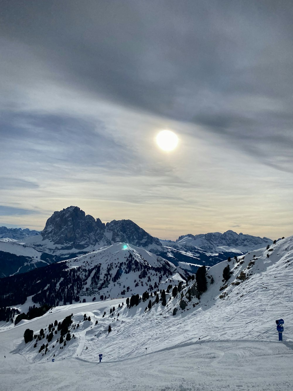 the sun is setting on a snowy mountain