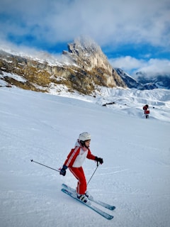 A young girl skiing down a snowy slope in the French Alps.