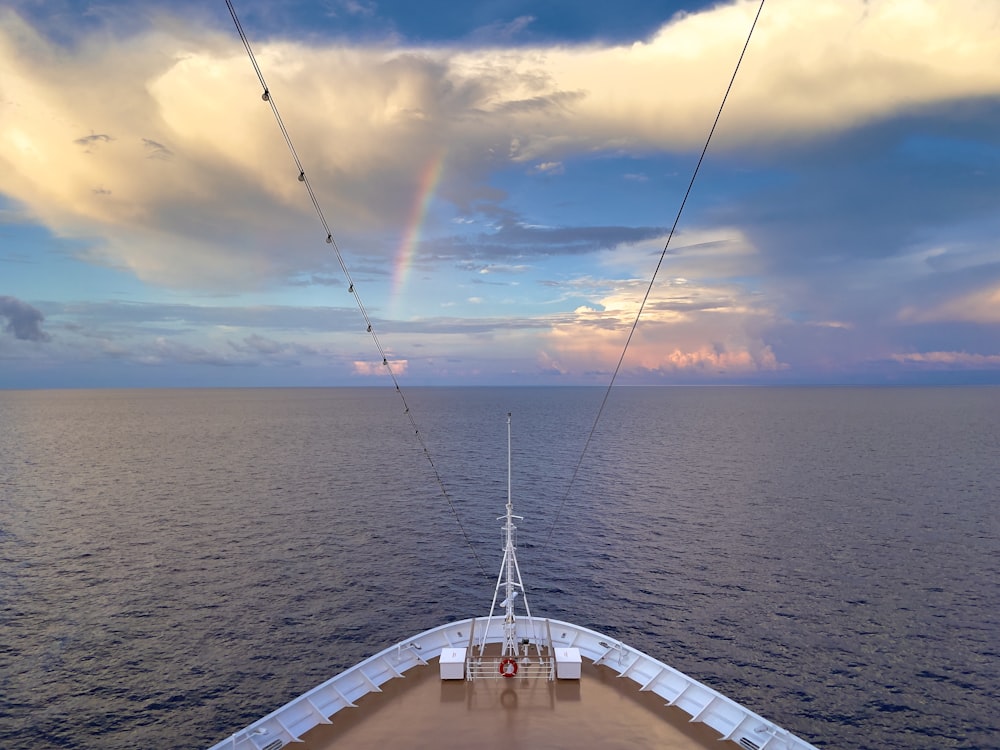 a view of the back of a boat with a rainbow in the sky