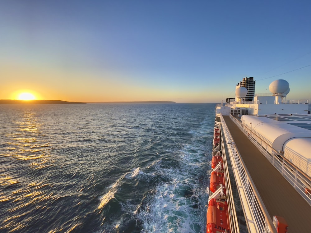 the sun is setting over the ocean on a cruise ship