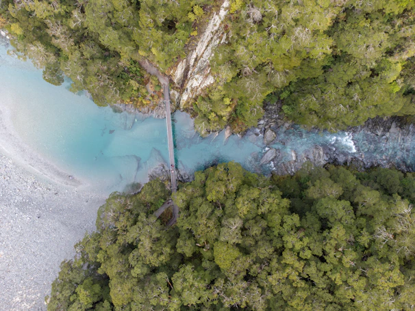 Dynamic drone shot capturing the flow of the Cisadane River surrounded by dense forest.