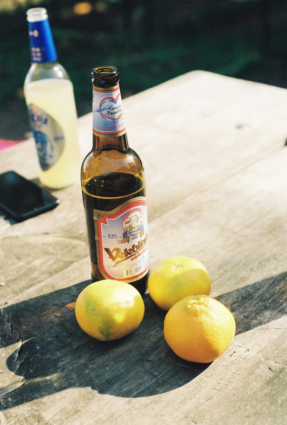 a bottle of beer and some lemons on a table