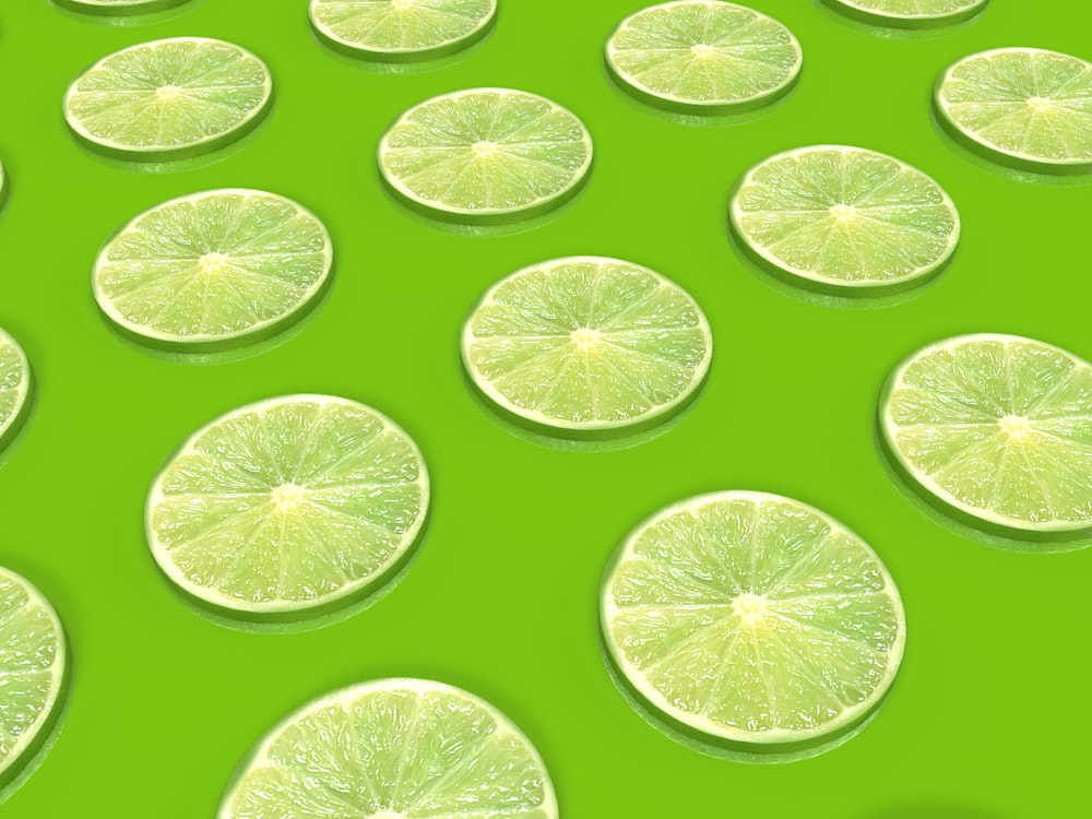 a group of lime slices sitting on top of a green surface