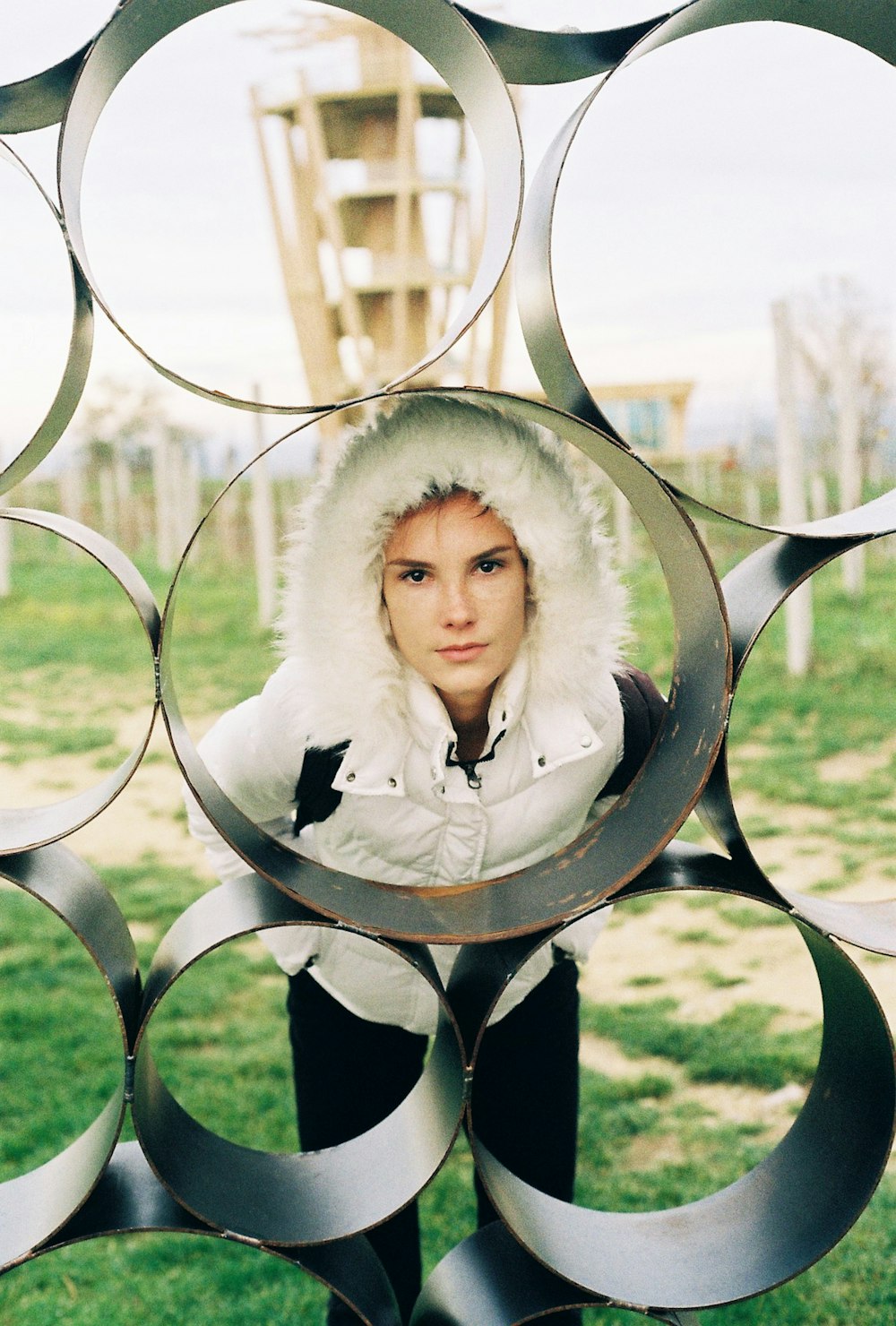 a woman in a white jacket and a bunch of metal circles