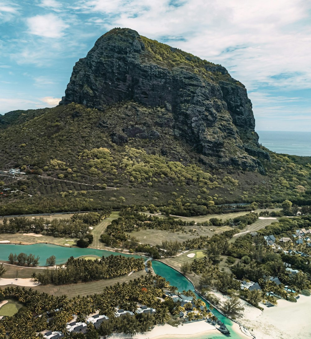 an aerial view of a tropical island with a mountain in the background