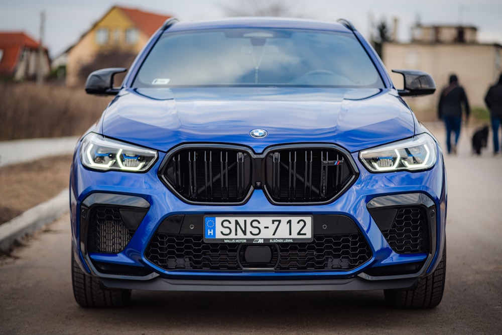 a blue bmw suv parked on a street