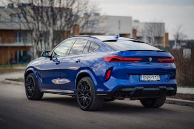 a blue bmw suv parked on the side of the road