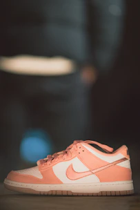 Close-up of pastel pink men's sneakers on a light pastel surface with subtle shadows