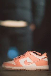 Casual yet chic sneakers in pastel tones, positioned on a soft white background with a hint of pink