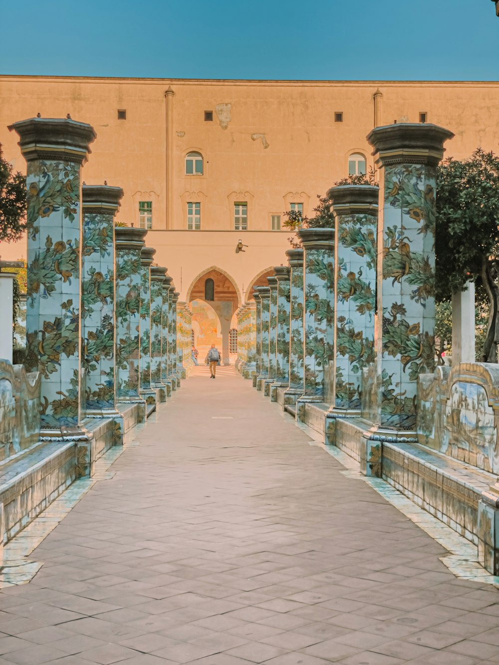 a walkway leading to a building with a clock tower in the background