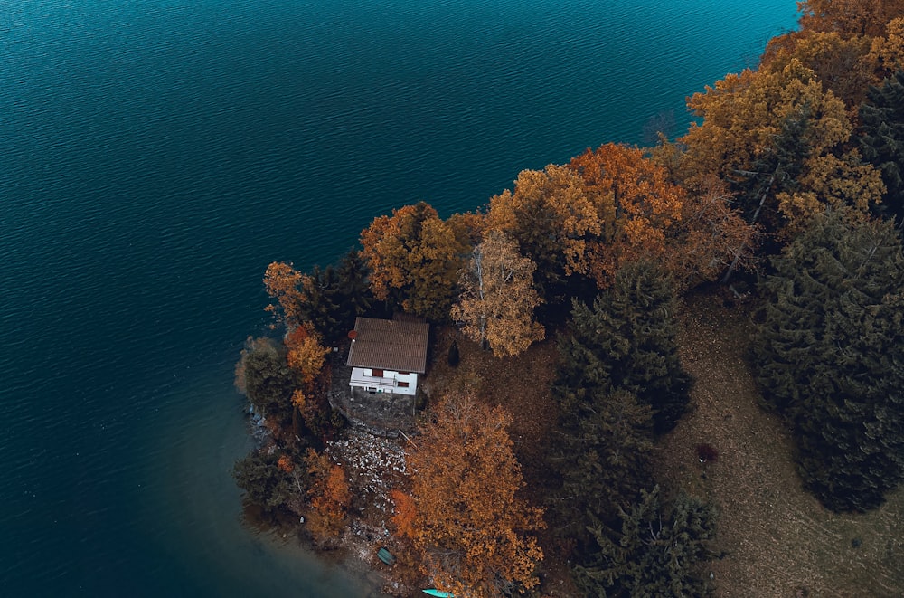 an aerial view of a house on a small island in the middle of a lake