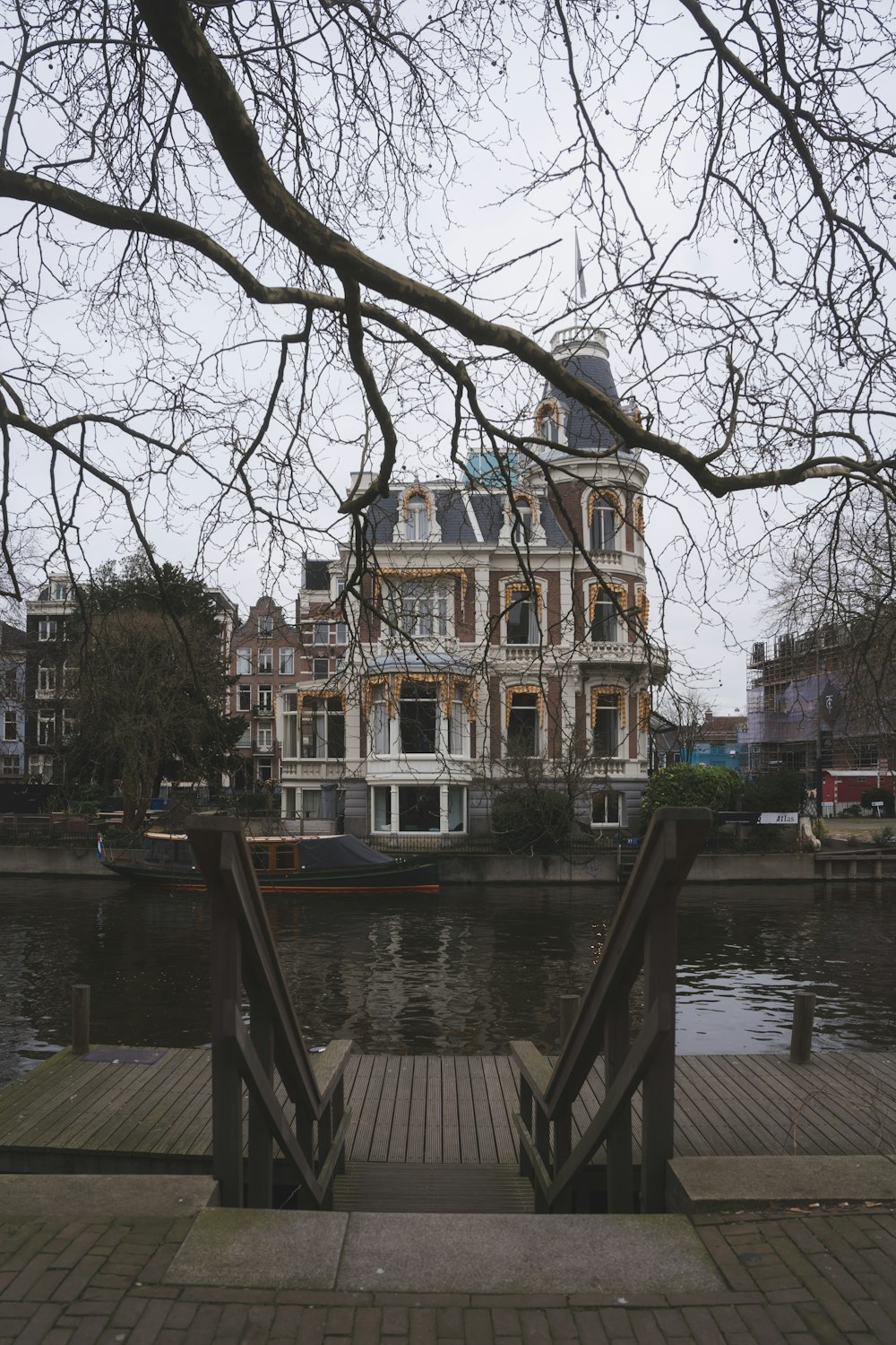 a wooden walkway leading to a large building next to a body of water