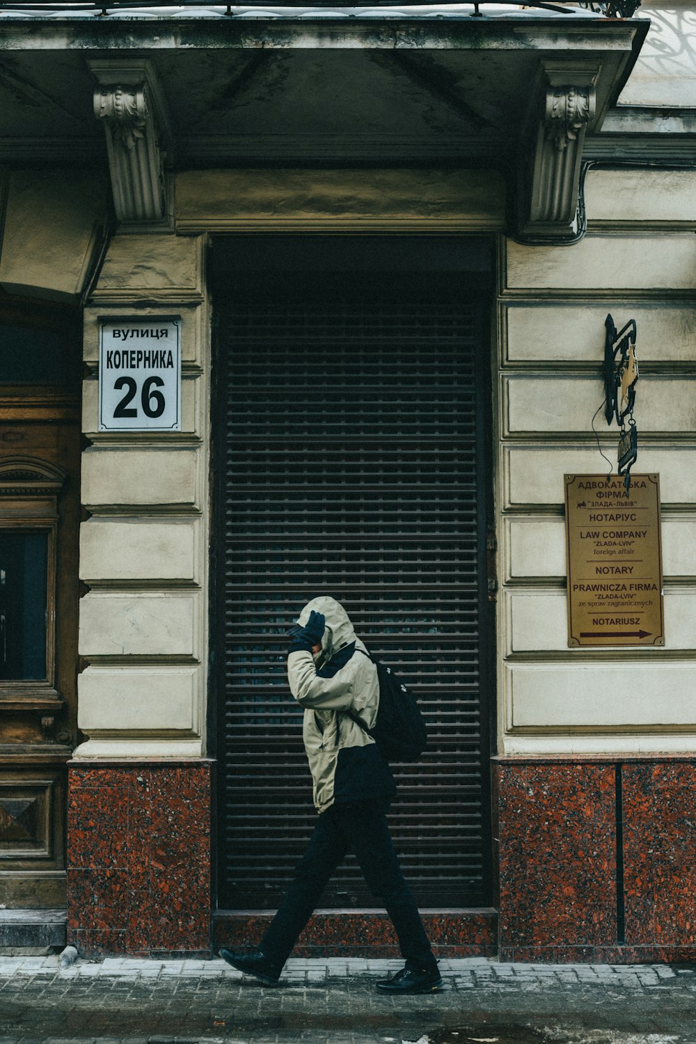 una persona che cammina lungo una strada di fronte a un edificio