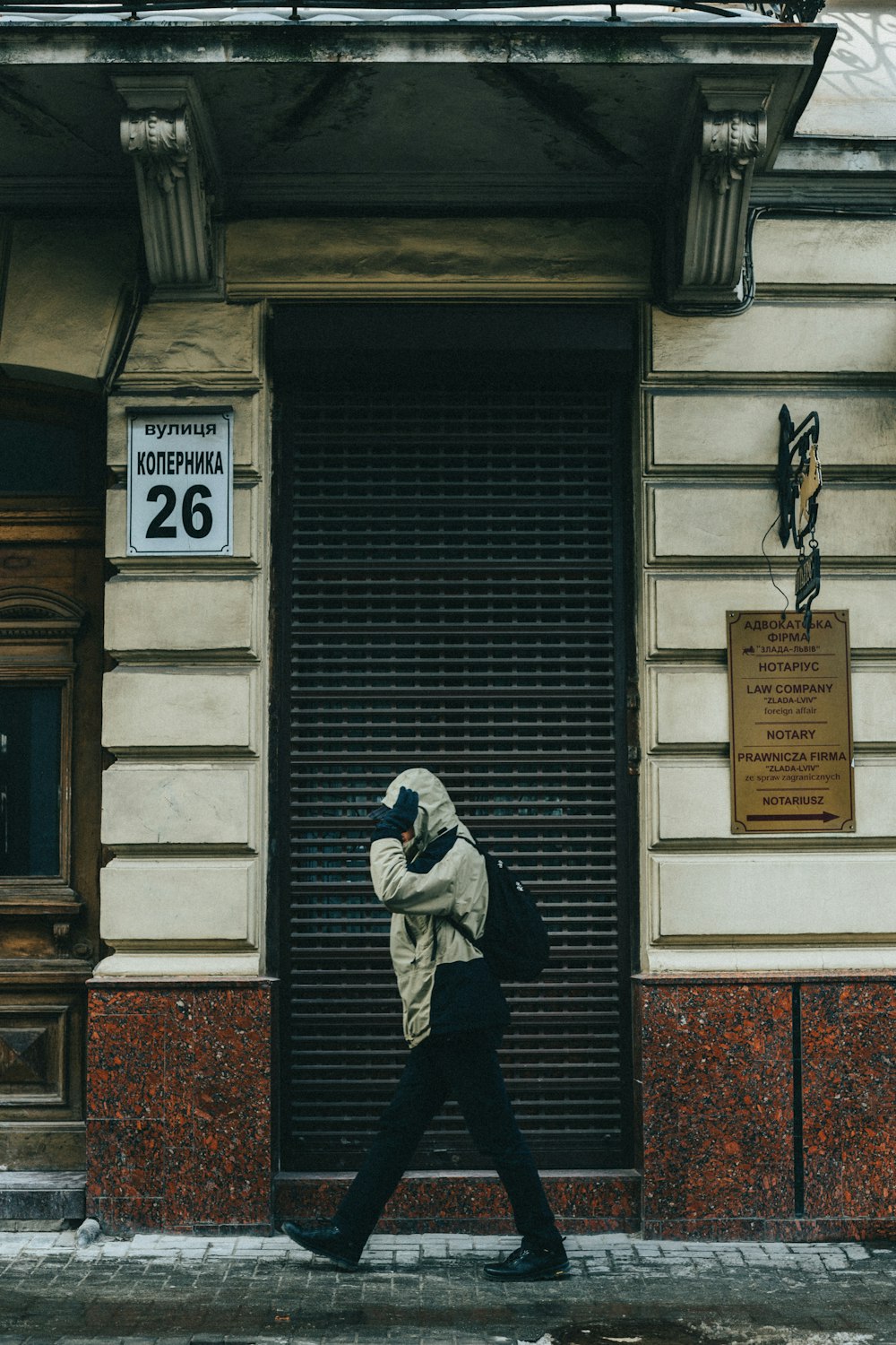 a person walking down a street in front of a building