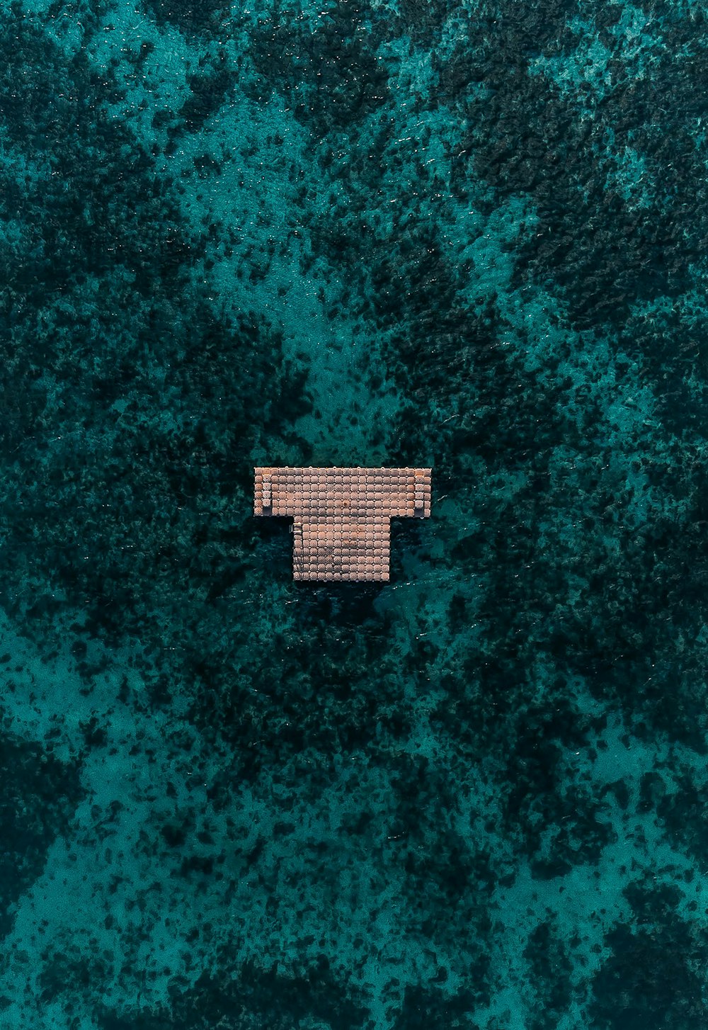 an aerial view of a house in the middle of the ocean