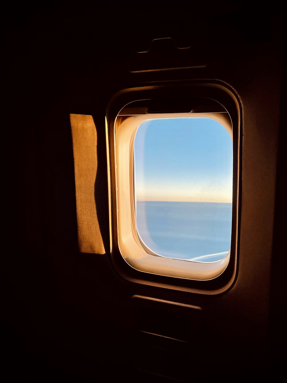 an airplane window with a view of the ocean