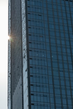 Commercial building with glass facade reflecting sunlight.