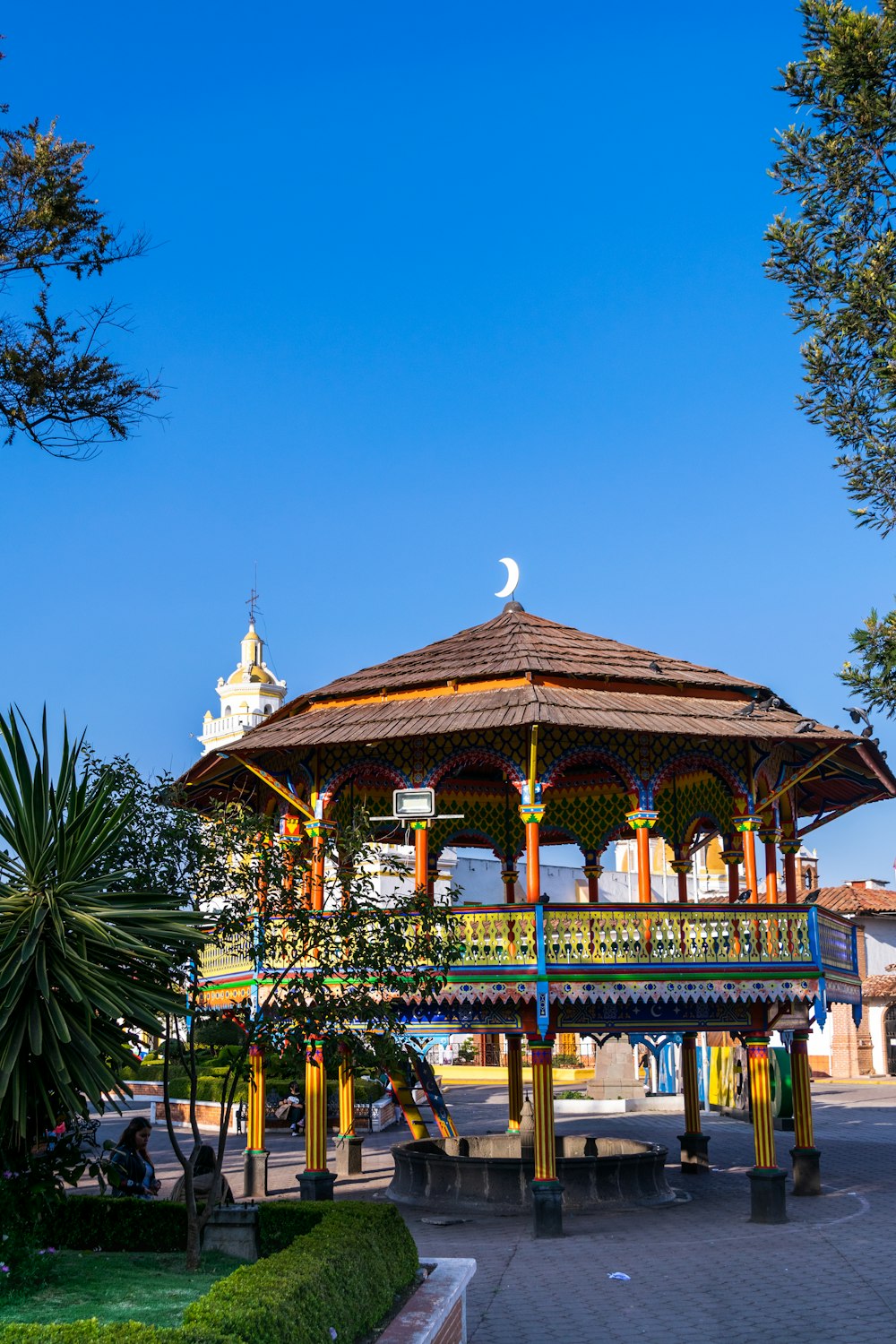 a gazebo in a park with a full moon in the background