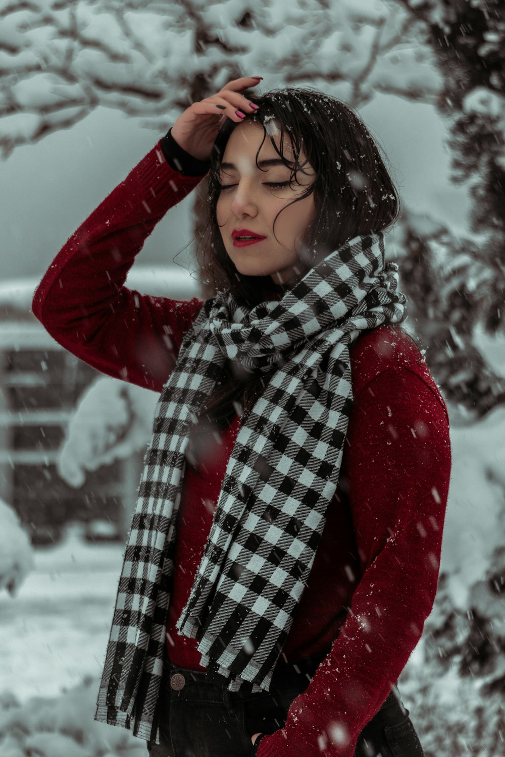 a woman standing in the snow wearing a scarf