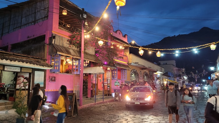 A vibrant street in Tepoztlán with colorful buildings and locals enjoying a sunny day.