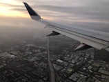 An early morning city skyline viewed from the cockpit of a small plane.