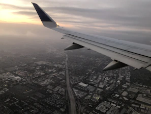 A panoramic view of a bustling city skyline from a plane window at dawn