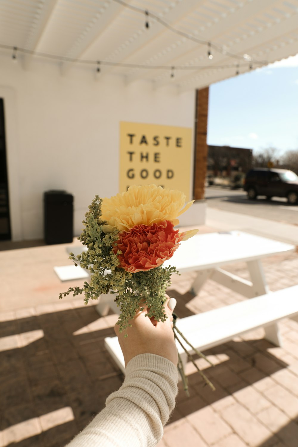 a person holding a bouquet of flowers in front of a table