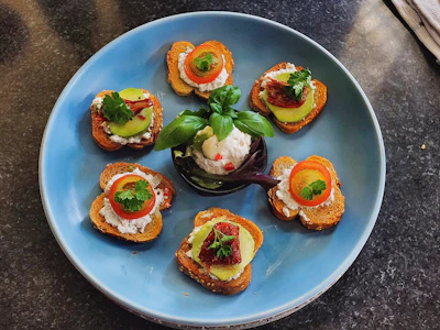 A beautifully plated bruschetta topped with ripe tomatoes, basil, and a drizzle of olive oil.