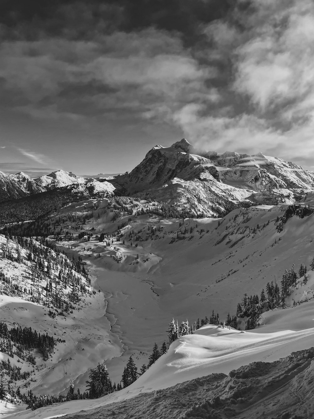 a black and white photo of a snow covered mountain