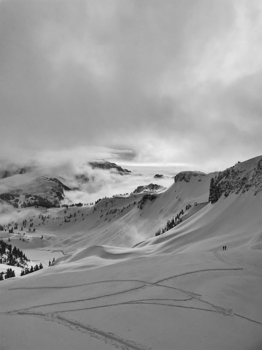 a black and white photo of a snowy mountain