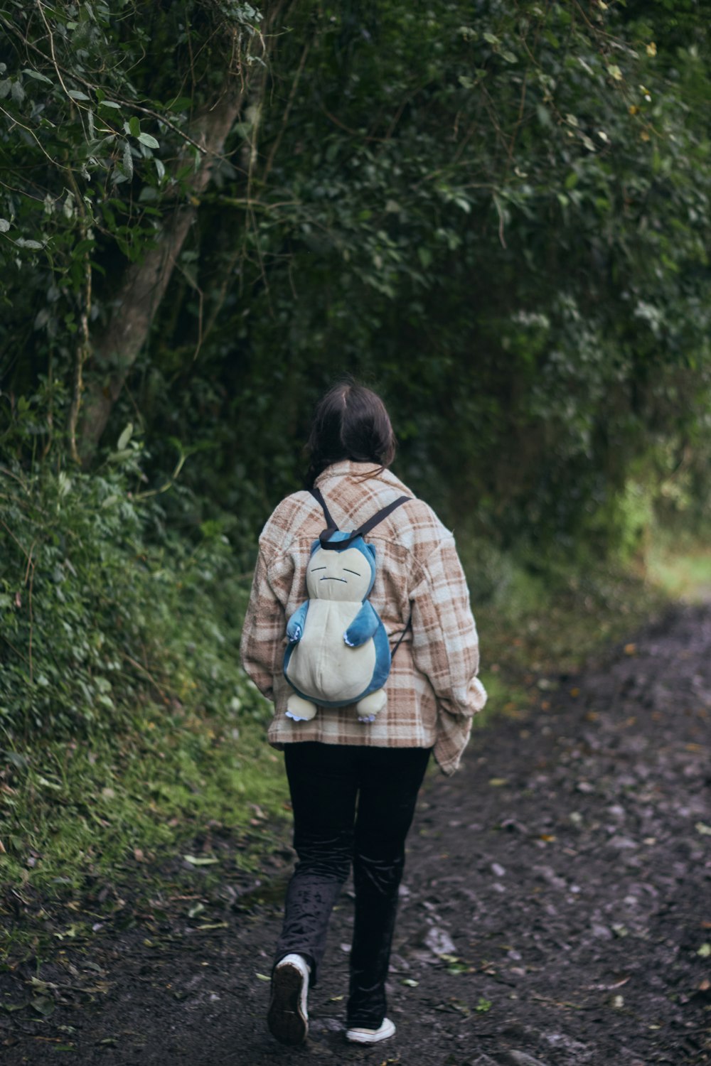 a person with a backpack walking down a dirt road