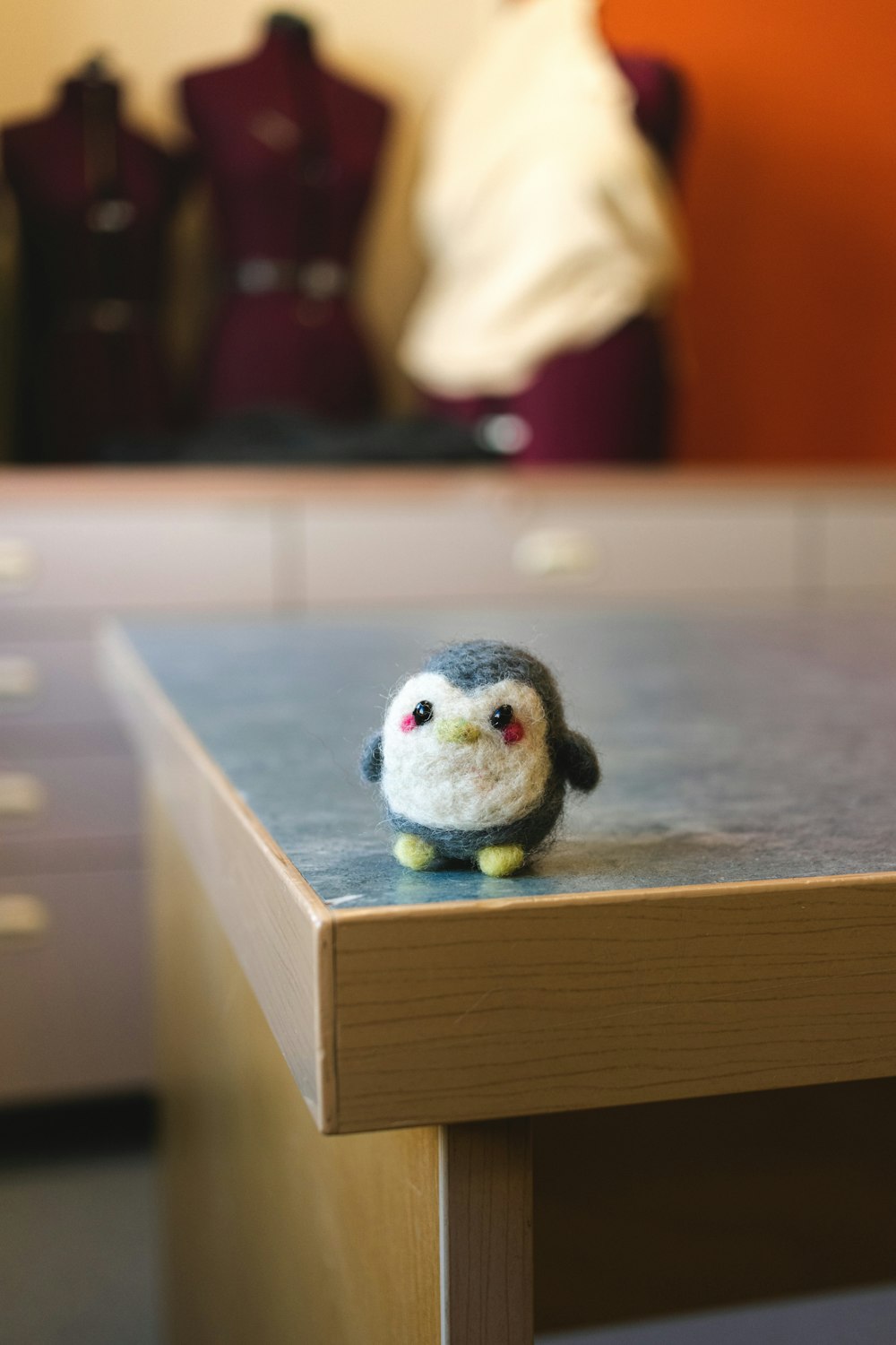 a small bird sitting on top of a wooden table